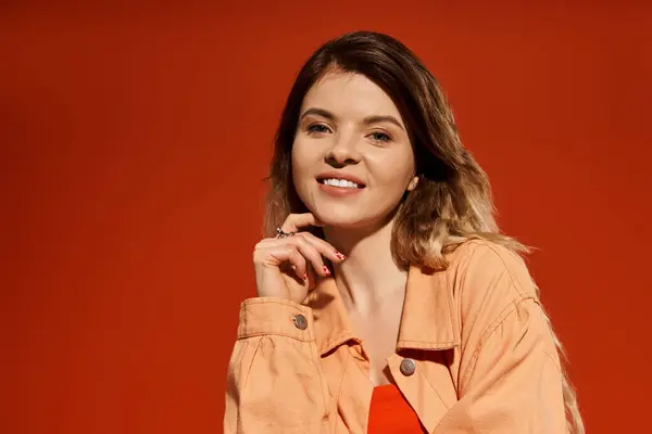 Красивая молодая женщина уверенно улыбается, одетая в яркий наряд, который прекрасно выделяется. — стоковое фото