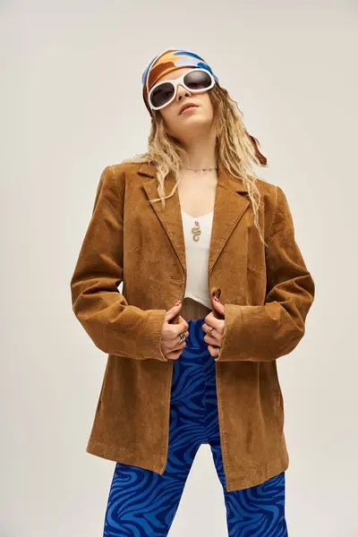 Charming young woman poses confidently in a trendy outfit with a grey background. — Stock Photo
