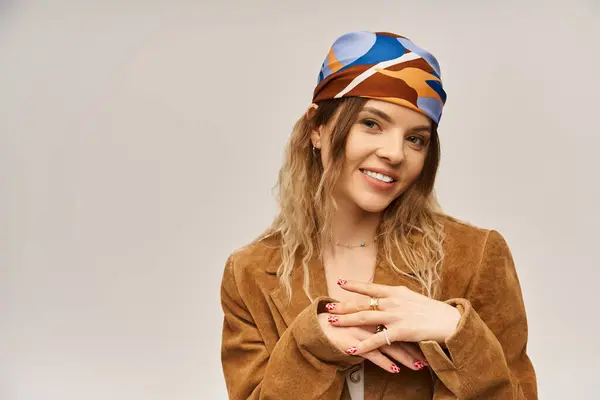Une belle jeune femme pose avec confiance, portant une tenue élégante et un foulard vibrant. — Photo de stock