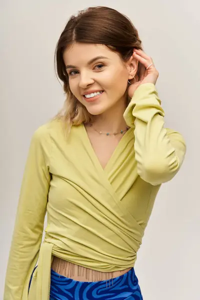 A beautiful young woman poses confidently in a chic outfit, radiating style and joy. — Stock Photo