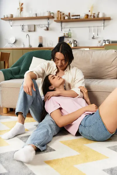 Um casal compartilha um momento terno sentado no chão, envolto em amor e carinho em casa. — Fotografia de Stock