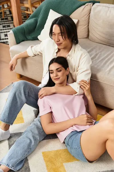 A couple relaxes together on a comfortable rug in their living room, enjoying intimacy and joy. — Stock Photo