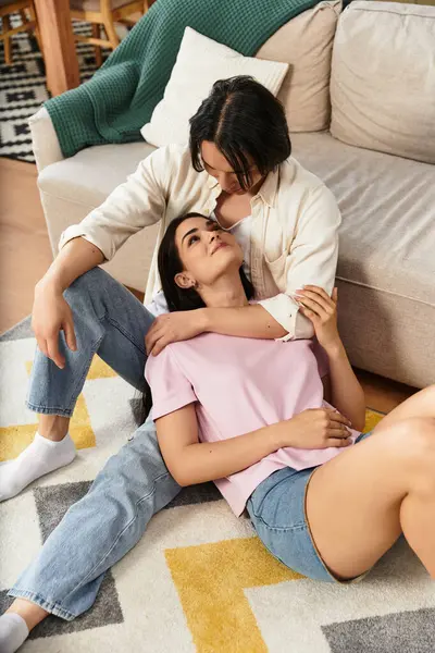 Couple relaxes on the floor, sharing sweet glances and affection in their living space. — Stock Photo