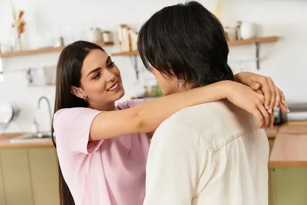 A couple embraces tenderly in their kitchen, enjoying a sweet moment of love and connection. — Stock Photo