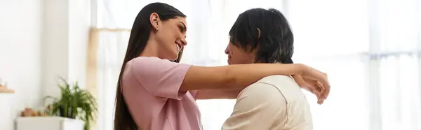 Couple shares a warm embrace, enjoying a heartfelt moment in their inviting living space. — Stock Photo