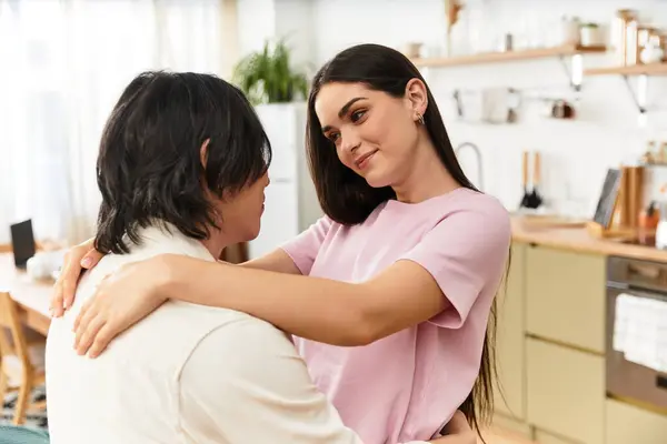 La coppia si abbraccia nel loro invitante spazio abitativo, scambiandosi sguardi amorevoli e sorrisi. — Foto stock