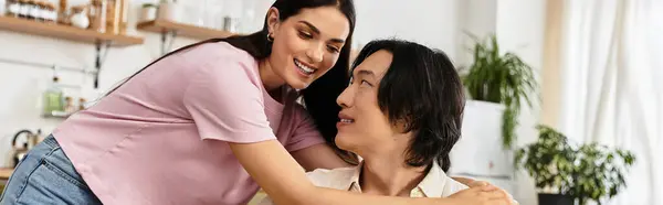 A man and woman smile and embrace each other joyfully while sitting at home together. — Stock Photo
