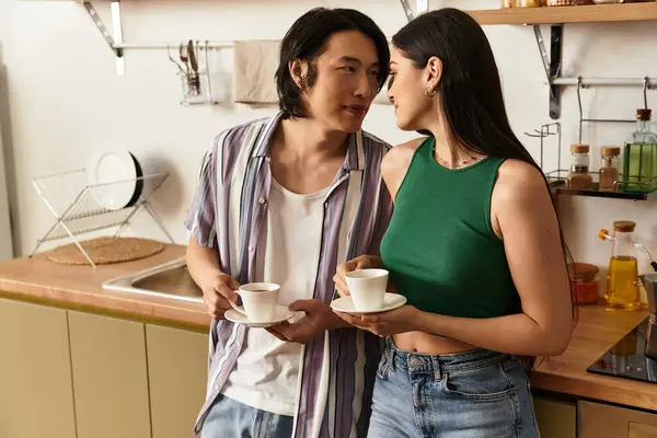 Casal amoroso gosta de café juntos, trocando sorrisos e calor em sua cozinha convidativa. — Fotografia de Stock
