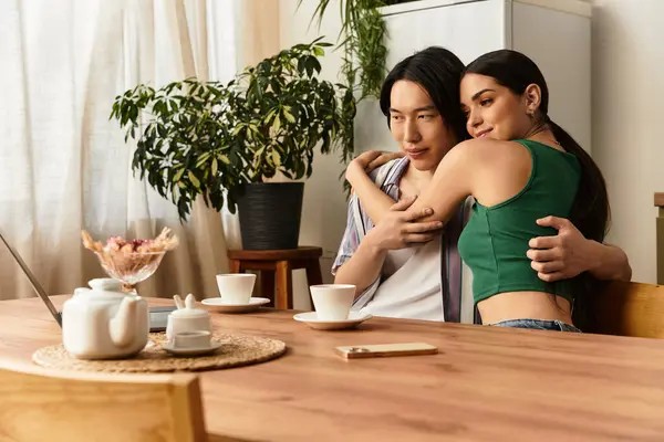 Ein Paar sitzt an einem warmen Holztisch und umarmt sich zärtlich, während es Kaffee schlürft. — Stockfoto