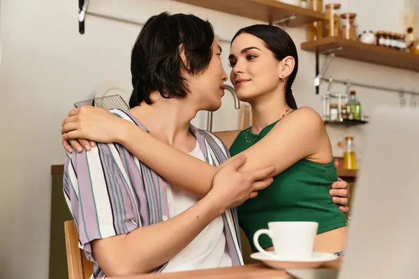 Um casal caloroso e afetuoso desfruta de um abraço próximo, enquanto cercado por sua decoração de cozinha. — Fotografia de Stock