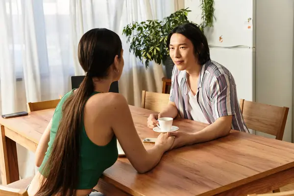 Ein Paar genießt die Gesellschaft des anderen, teilt Lächeln und Kaffee an seinem rustikalen Holztisch. — Stockfoto