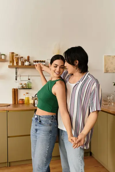Loving couple enjoys a joyful moment as they dance together in their warm, inviting kitchen. — Stock Photo