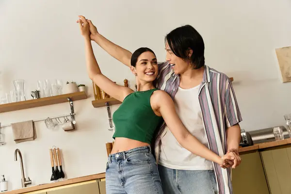 Couple enjoys a delightful dance in their cozy kitchen, celebrating their love and connection. — Stock Photo