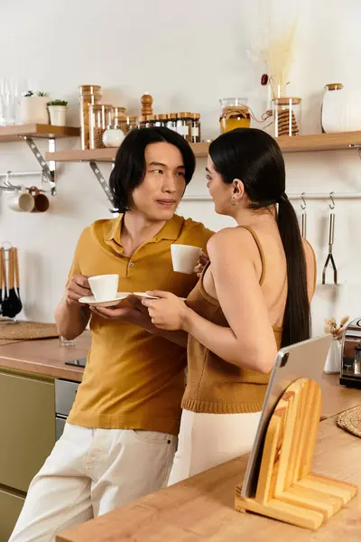 In einer gemütlichen Küche teilt ein Paar zärtliche Momente, während es Tassen Kaffee genießt und Liebe ausstrahlt. — Stockfoto