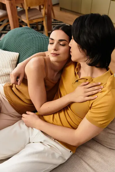 Ein Paar umarmt sich zärtlich auf einem Sofa und zeigt seine tiefe Liebe und Verbundenheit in einem ruhigen Zuhause. — Stockfoto