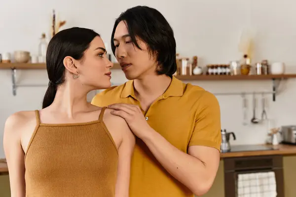 Pareja comparte un momento tierno, sonriendo y conectándose en su acogedora cocina. - foto de stock