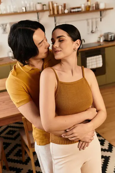 A loving couple shares an intimate moment at home, surrounded by a cozy kitchen ambiance. — Stock Photo