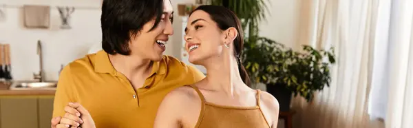 A loving couple joyfully dances in their warm and inviting living room, embracing each other. — Stock Photo
