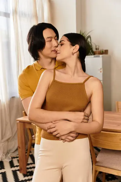 Pareja comparte un momento tierno, envueltos en los brazos del otro, expresando un profundo afecto en casa. - foto de stock