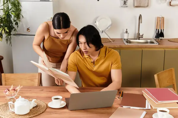 Warm moments shared as a couple looks through a book together in their inviting kitchen space. — Stock Photo