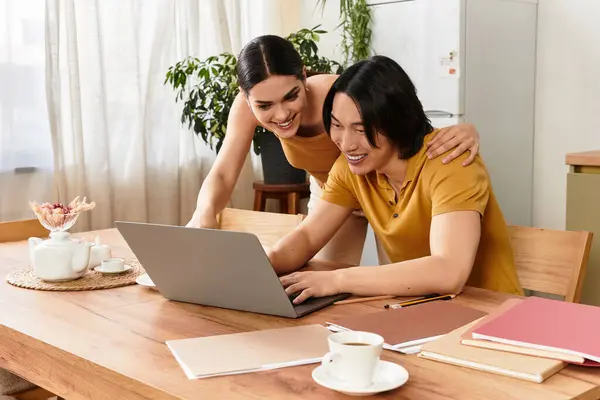 Loving couple shares laughter and connection while working on a laptop in their cozy home. — Stock Photo