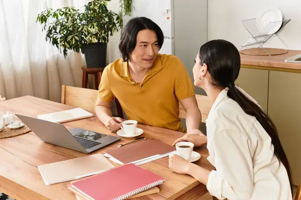 A couple shares coffee at home, smiling and engaging in warm conversation together. — Stock Photo