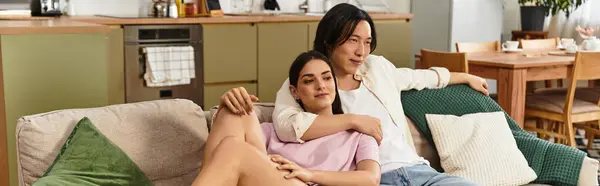 A couple enjoys each others embrace on a comfortable couch in their inviting home, radiating love. — Stock Photo
