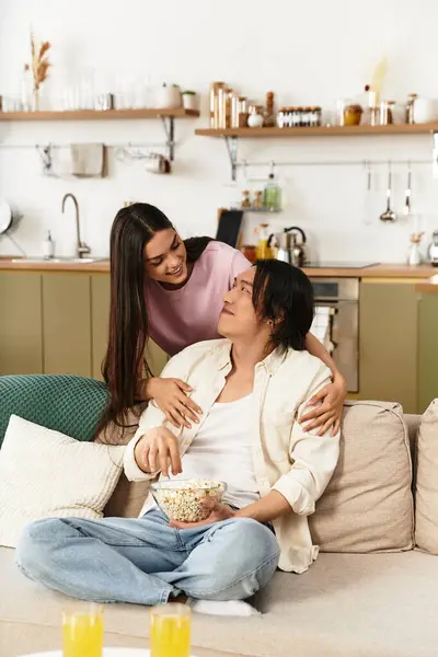 Um homem e uma mulher desfrutam de um momento terno juntos em casa cercados por uma decoração acolhedora e lanches. — Fotografia de Stock