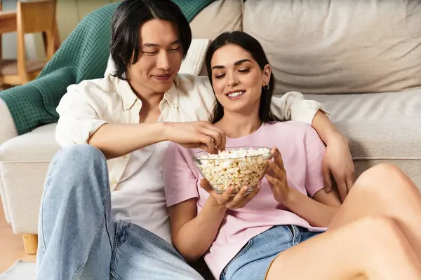 Ein Paar genießt Popcorn auf dem Fußboden, umarmt sich an einem warmen Abend. — Stockfoto
