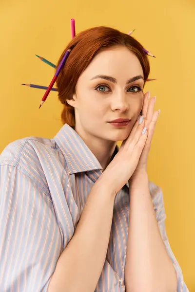 Una giovane donna sorride dolcemente con matite colorate disposte giocosamente nei suoi capelli. — Foto stock