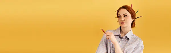 A beautiful young woman playfully displays creativity while immersed in a sunny workspace. — Stock Photo