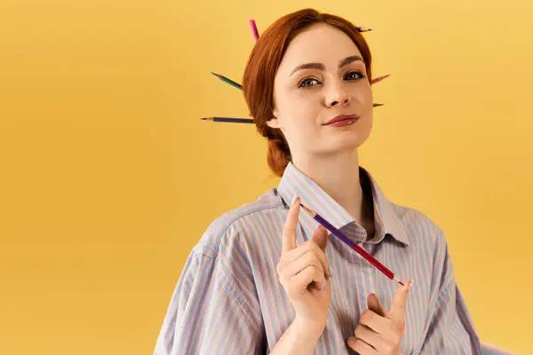 Una giovane donna mette giocosamente in mostra matite colorate nei suoi capelli, irradiando creatività. — Foto stock