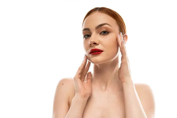 Uma jovem mulher deslumbrante acaricia suavemente seu rosto, destacando suas características impecáveis e elegância. — Fotografia de Stock