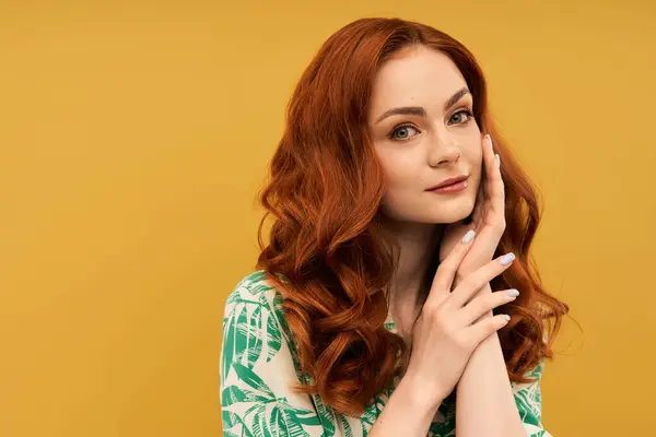 Une superbe jeune femme aux cheveux roux fluides touche doucement son visage, respirant confiance et charme. — Photo de stock