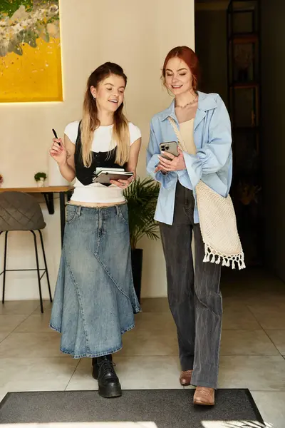 Migliori amici condividono un momento gioioso, discutendo piani e utilizzando il telefono in un accogliente caffè. — Stock Photo