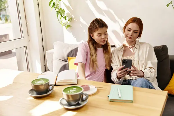 Dois amigos sorriem para um telefone, curtindo café matcha em um café ensolarado. — Fotografia de Stock