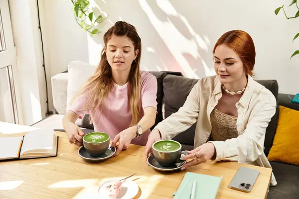 In einem trendigen Café teilen sich zwei Freunde einen Moment, während sie ihre Matcha-Drinks genießen. — Stockfoto