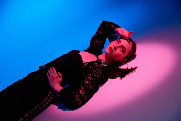 Una joven mujer abraza su sentido de la moda con confianza bajo las luces del estudio. - foto de stock