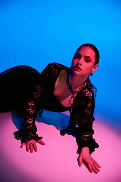 Una giovane donna modella un vestito elegante in un ambiente da studio rosa e blu. — Foto stock