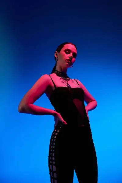 Young woman showcases her unique fashion sense in a stylish outfit, captured with colorful lighting. — Stock Photo