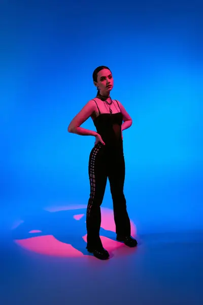 Young woman displays her fashion in a vibrant studio with bold lighting. — Stock Photo