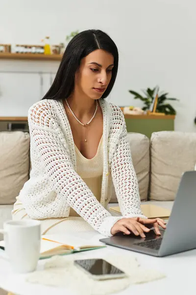 A serene young woman works on her laptop, embracing pregnancy in a cozy home setting. — Stock Photo