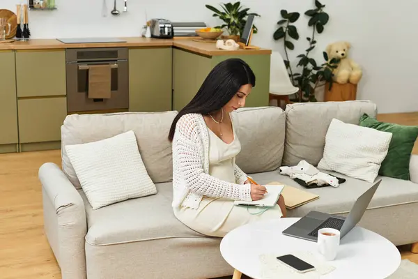 In uno spazio luminoso, una giovane donna incinta si rilassa e scrive nel suo quaderno.. — Stock Photo