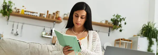 Em um ambiente interior sereno, uma mulher grávida se concentra em seu diário enquanto está sentada confortavelmente. — Fotografia de Stock