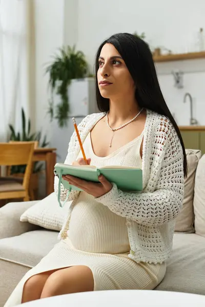 Erwartungsvolle Mutter beim nachdenklichen Journalismus in einem ruhigen, mit grünen Pflanzen geschmückten Raum. — Stockfoto