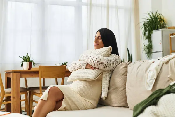 Expecting mother enjoys a peaceful moment in her stylish home, surrounded by warmth and nature. — Stock Photo