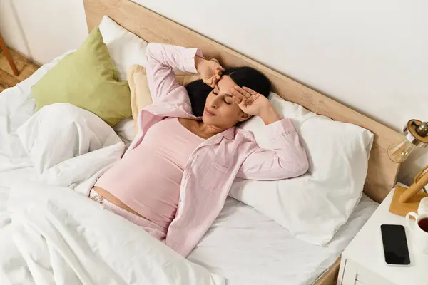 Expecting mother takes a moment to unwind in her cozy bedroom during a tranquil morning. — Stock Photo