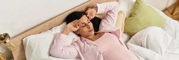 Expecting mother rests comfortably in soft bedding, embracing tranquility during her pregnancy. — Stock Photo