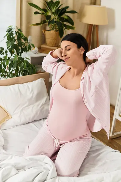Uma bela mulher grávida desfruta de uma manhã tranquila, estendendo-se em seu quarto acolhedor. — Fotografia de Stock