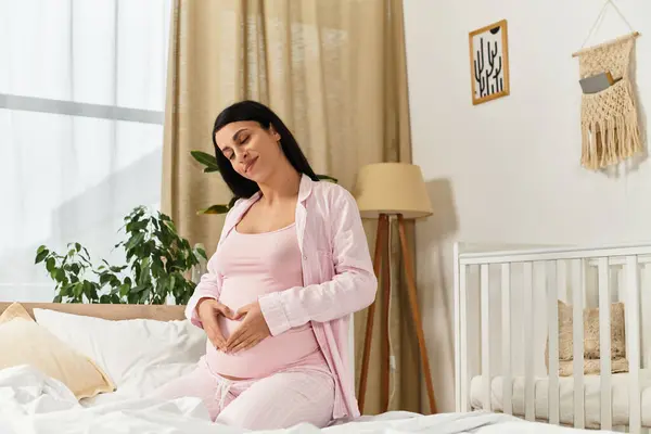 Beautiful young woman lovingly cradles her baby bump in a serene and cozy bedroom atmosphere — Stock Photo